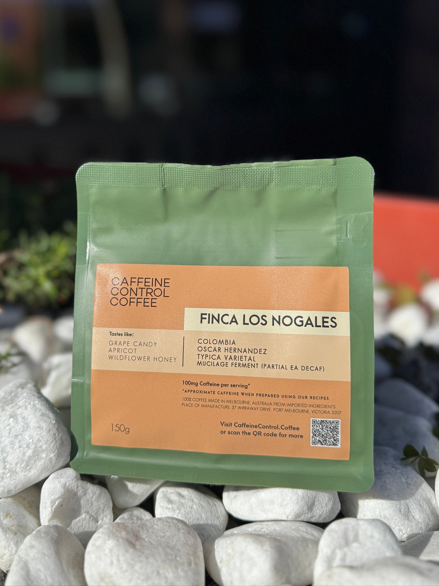 Coffee package labeled 'Finca Los Nogales' on a stone surface with a blurred natural background
