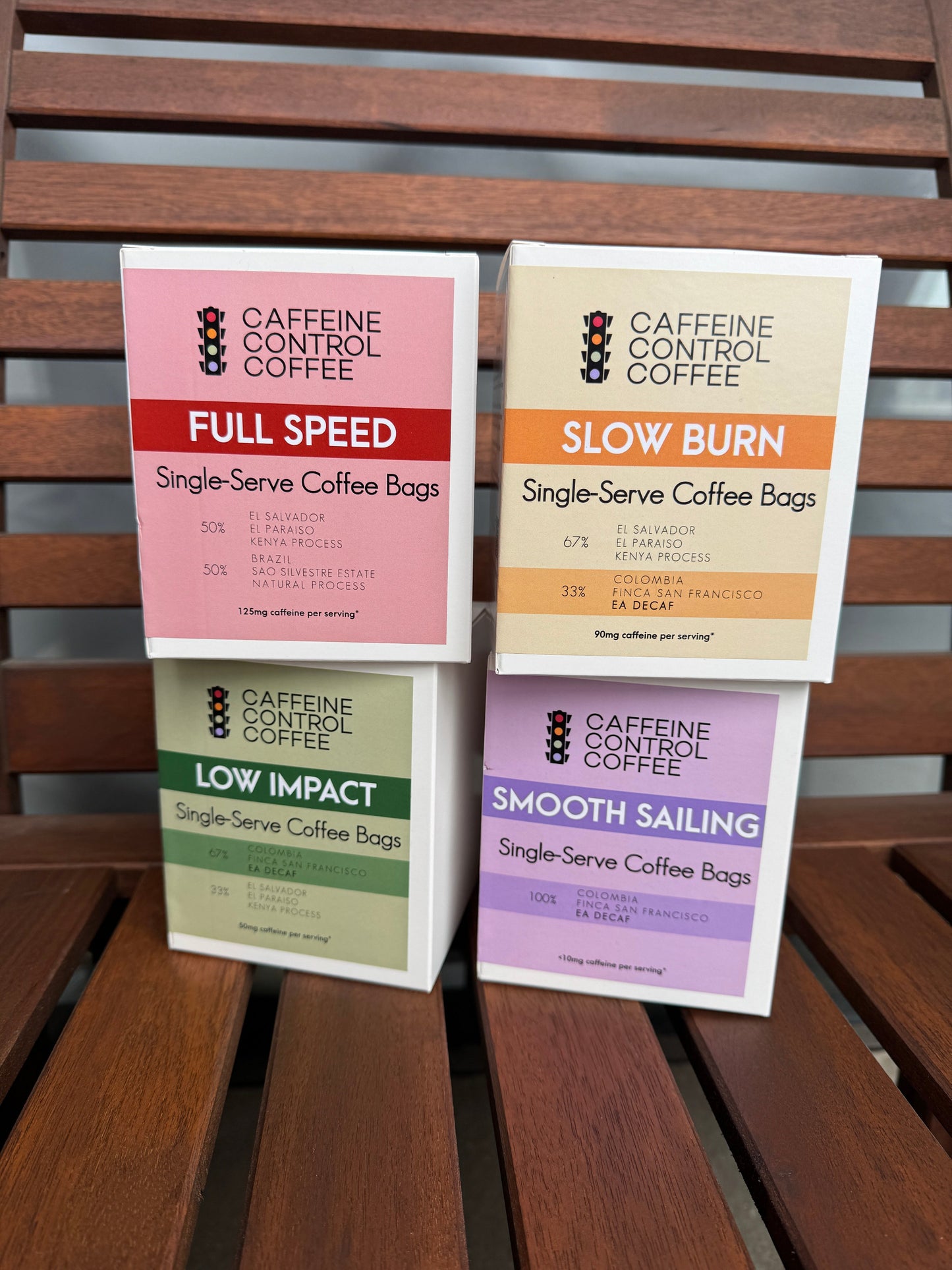 Four packages of Caffeine Control Coffee on a wooden surface